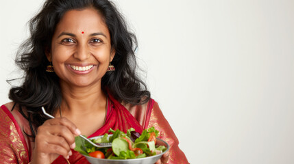 Portrait of a smiling 25+ indian woman enjoying a salad