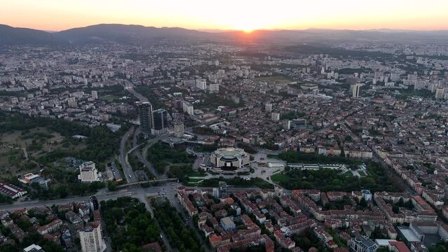 4K Aerial view of sunset or sunrise of the center of the capital of Bulgaria - Sofia. Architectural and emblematic buildings from the communist era, NDK - National Palace of Culture. Night lights