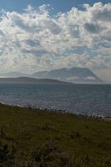 View of mountains from Lyngen over fjord in cloudy summer weather, Norway. 