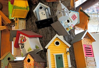 Obraz na płótnie Canvas Birdhouses painted in yellow, gray, brown, blue colors are decorative for decorating the garden, yard, hanging on a tree trunk