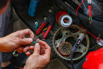 selective focus wires in the hand of a car mechanic Practicing repairs to the ATV's electrical system. Wires of various colors help you know the direction of your car's electrical system.