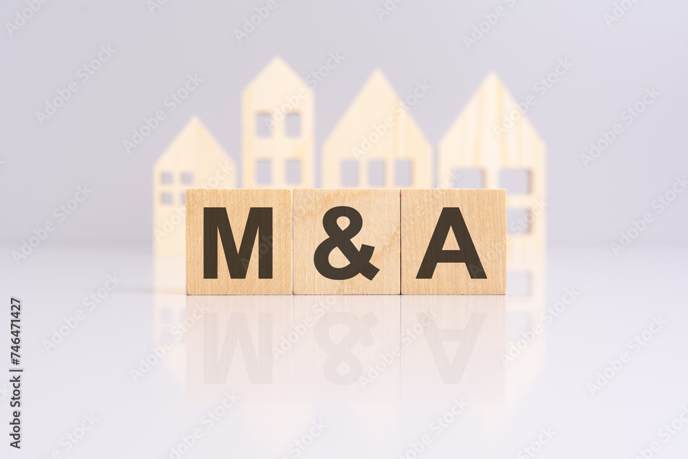 Poster the image shows three wooden blocks with the word m and a on a gray table. there is a small wooden m