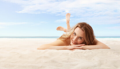 Smiling woman lying on sand beach, panoramic background with a sky and big sea horizon for copy space for text and logo. Concept of summer beach holiday or vacation travel, skin care protection