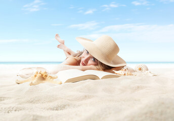 Fototapeta na wymiar Woman lying on sand beach with book, sunbathing wearing sun straw hat. Concept of summer beach holiday and vacation travel. Sea and blue sky in Background. Sunglasses and seashell in foreground