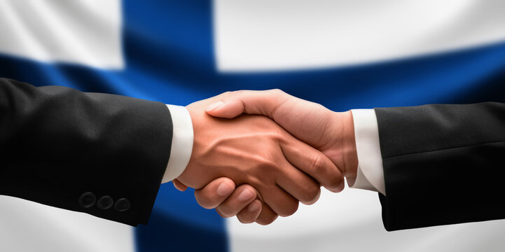 Businessman, diplomat in suits clasp hands for handshake over Finland flag, agree on united success in trade, diplomacy, cooperation, negotiation, support, teamwork in commerce, gesture of greeting