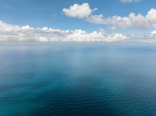 Blue sea surface with corals. Blue sky and clouds. Boracay, Philippines.