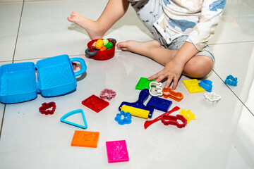 child playing at home, wearing pajamas, lots of messy toys