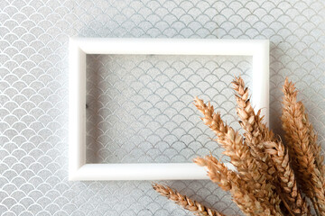 Bunch of wheat ears and photo frame on silver background. Agriculture concept in minimalism style....