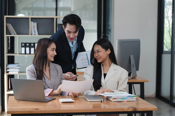 Professional team of Asian businesspeople collaborating on a new project in an office room.