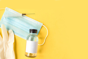Face medical mask and hand sanitizer on bright yellow background minimal. Coronavirus travel....