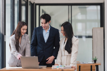 Successful business people working on their project together, using laptop computer as they discussed.