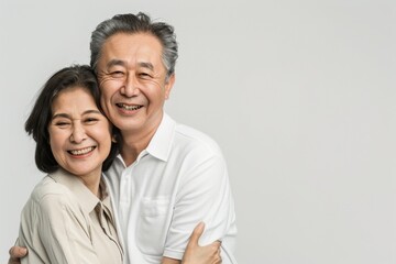 Obraz premium 二人で寄り添う仲良しな日本人の年配の夫婦（カップル・おしどり夫婦・友達夫婦）