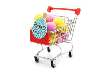 Shopping supermarket cart with red handle with colorful glitter easter eggs isolated on a white background. Happy easter! Purchase of products for the holiday.