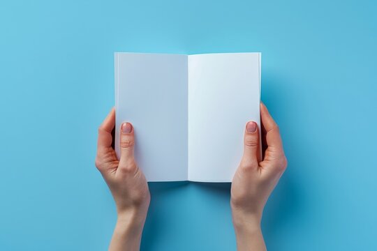 Woman hands holding folded blank paper sheet, empty booklet, double-pages book, magazine on light blue background. Mock up template. Generative AI