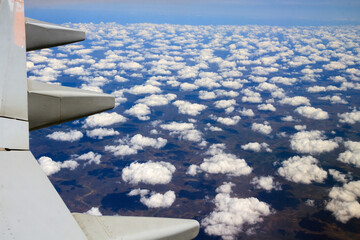 Fototapeta premium airplane flying over altocumulus clouds