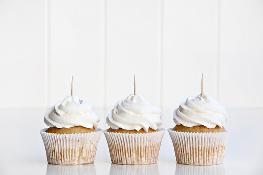 Three Vanilla Cupcakes Topper Mockup. 3 cupcake with wooden toothpick in white background Copy space for your design here. Blank mockup for advertising and promotions