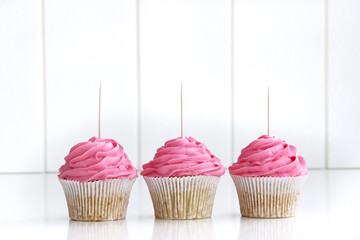 Three Pink Cupcakes Topper Mockup. 3 cupcake with wooden toothpick in white background Copy space...