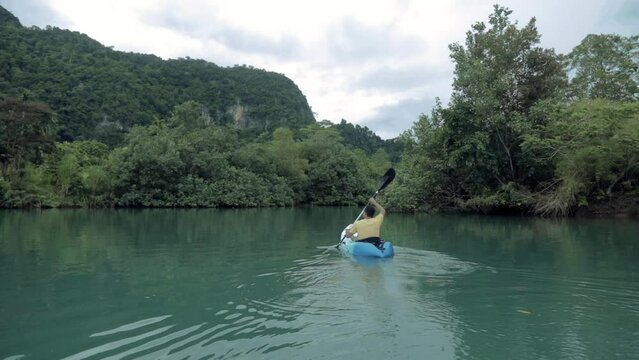 A man paddling alone on a river