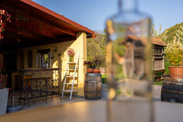  depicts a cozy outdoor patio with decorative metal railings, a wooden barrel with pumpkins, and a blurred foreground, possibly a bottle, suggesting a relaxing, autumnal atmosphere perfect for leisure