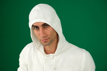 Portrait adult guy on isolate background. emotions of a handsome man guy on a green background chromakey close-up dark hair young man. white sweatshirt