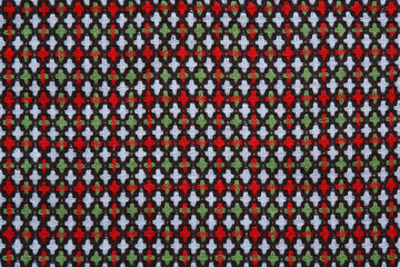 Red-white-green background made of fabric with an ornament.Fabric for sewing coats, skirts, furniture. Abstract background, texture. View from above.
