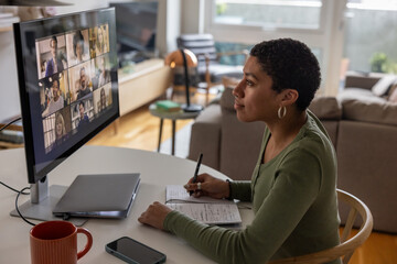 Young adult woman on a video conference call with colleagues working from home