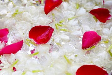 Water with jasmine flower and rose petals in silver bowl. Thai tradition, Songkran festival concept