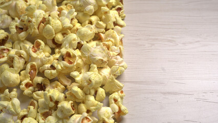 Caramel Popcorn is isolated on wooden background. Salted popcorn on the wooden table.