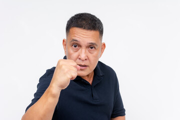 An asian man in his 50s showing a threatening pose ready to engage in a fight after being offended....