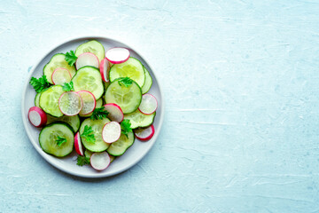 Fresh cucumber and radish salad with parsley, overhead flat lay shot. Simple vegan recipe on a slate background. Healthy diet, with a place for text - 746526883
