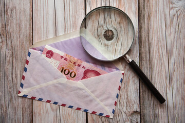 chiński banknot w kopercie ,lupa  - obrazy, fototapety, plakaty