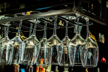 Wine glasses hanging from a stemware rack in a bar - 746529022