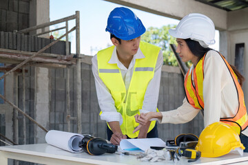 Civil engineer teams meeting working together wear worker helmets hardhat on construction site in modern city. Foreman industry project manager engineer teamwork. Asian industry professional team