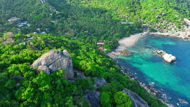 Emerald woodlands meet distinctive formations along the coast, where azure waters glisten in tranquility. Flight over the sea. Nature stock footage. Ko Tao, Surat Thani Province, Southern Thailand.  
