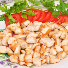 Fresh and fried chicken meat breast pieces, ready to cook, with tomato and parsley