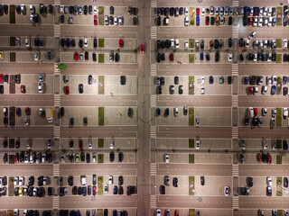 Aerial view of numerous cars of varying colors shapes and sizes neatly parked. Diversity concept.