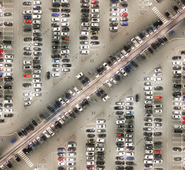 Aerial view of numerous cars of varying colors shapes and sizes neatly parked. Diversity concept.