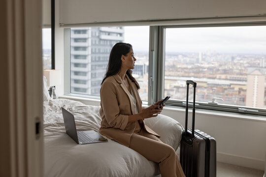 Business executive in hotel working using her cell phone