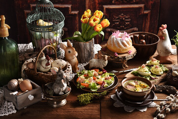 Rustic style Easter table with traditional white borscht, deviled eggs, salad and pastries