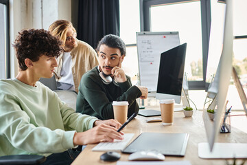 post production retouching team discussing project on monitor in modern office, professionals in 20s