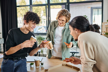 smiling men enjoying a pizza in a friendly and relaxed atmosphere, startup team having lunch break