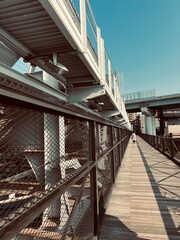 a metal bridge with stairs and steel railings with people walking