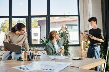 young man in glasses presenting ideas while holding notebook and talking to startup team on meeting