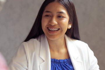 Woman with native features smiling. Formal outfit. Office, employment, study concept