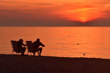 Fototapeta na wymiar couple watches the sunset over the sea