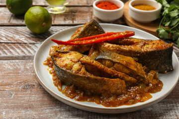 Tasty Indian fish curry on wooden table, closeup