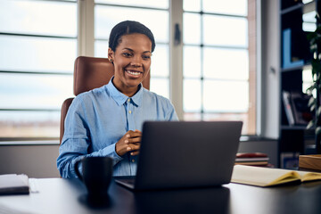 An African female boss, having an online meeting in her office, over the laptop.