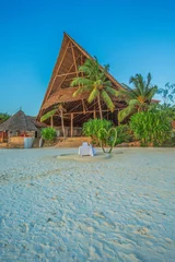 Tableaux ronds sur aluminium Plage de Nungwi, Tanzanie Palm trees and building at Zanzibar beach