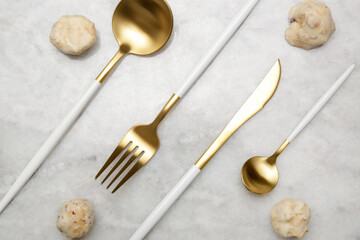 Creative shot of golden cutlery on marble table, Design concept. Modern kitchen. Scandinavian style...