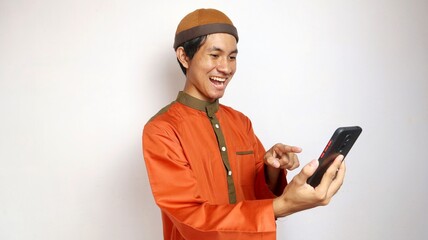 asian muslim man with holding gesture pointing towards smartphone